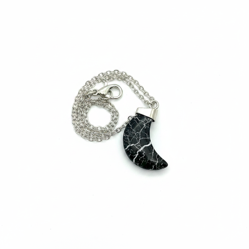 Black crackle crescent moon necklace with black and white vein stone pendant on silver chain, white background