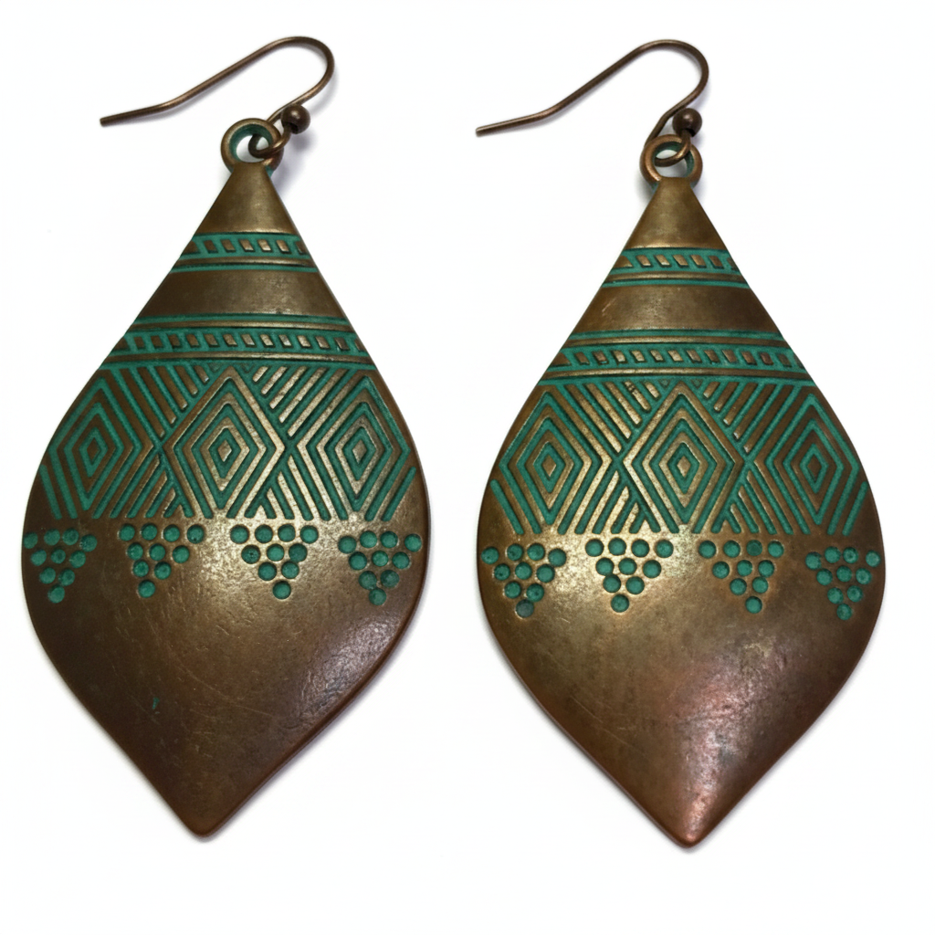 Large marquise copper earrings with teal-green patina and tribal engraving on white background