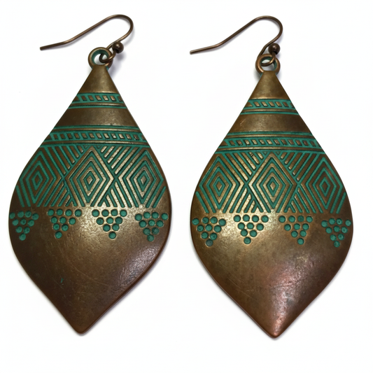 Large marquise copper earrings with teal-green patina and tribal engraving on white background