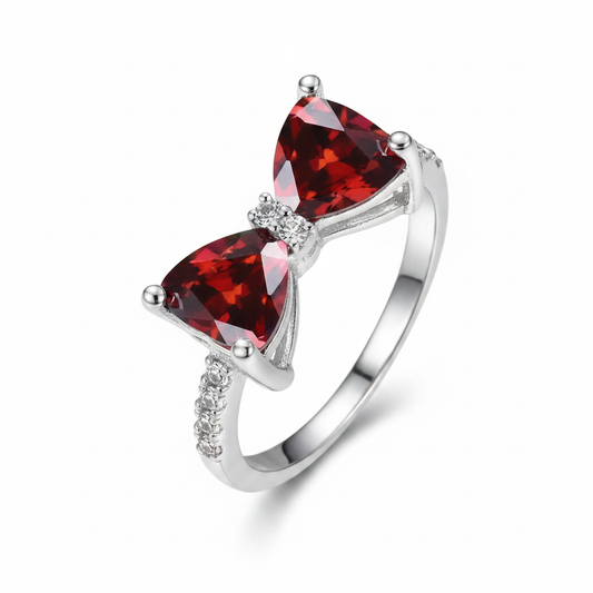 Silver ring with two deep red heart-shaped gemstones and crystal accents on white background