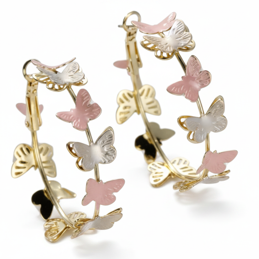 Large hoop earrings with flat butterfly silhouettes in pink silver and gold threaded on hoop wire on white background