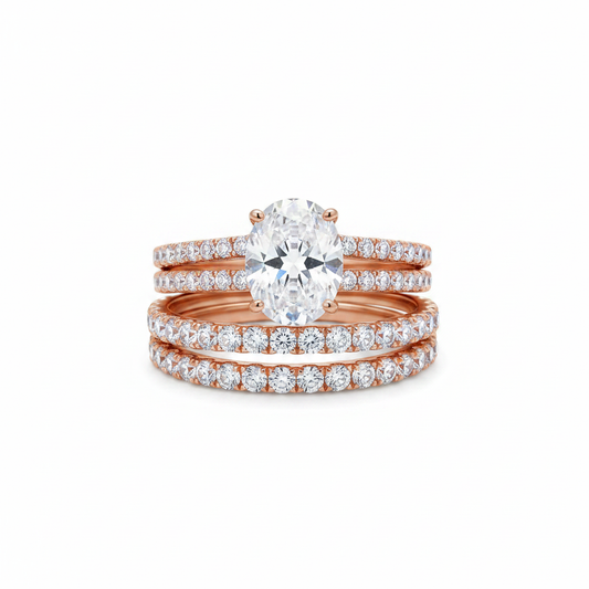 Rose gold-tone oval CZ solitaire and triple-row pavé eternity band ring set on pure white background