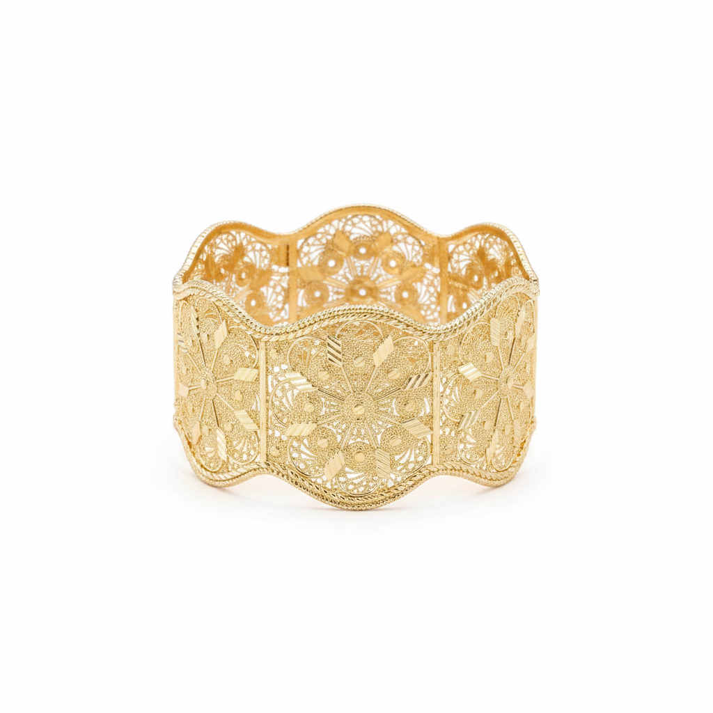 Gold filigree closed bangle bracelet on white background