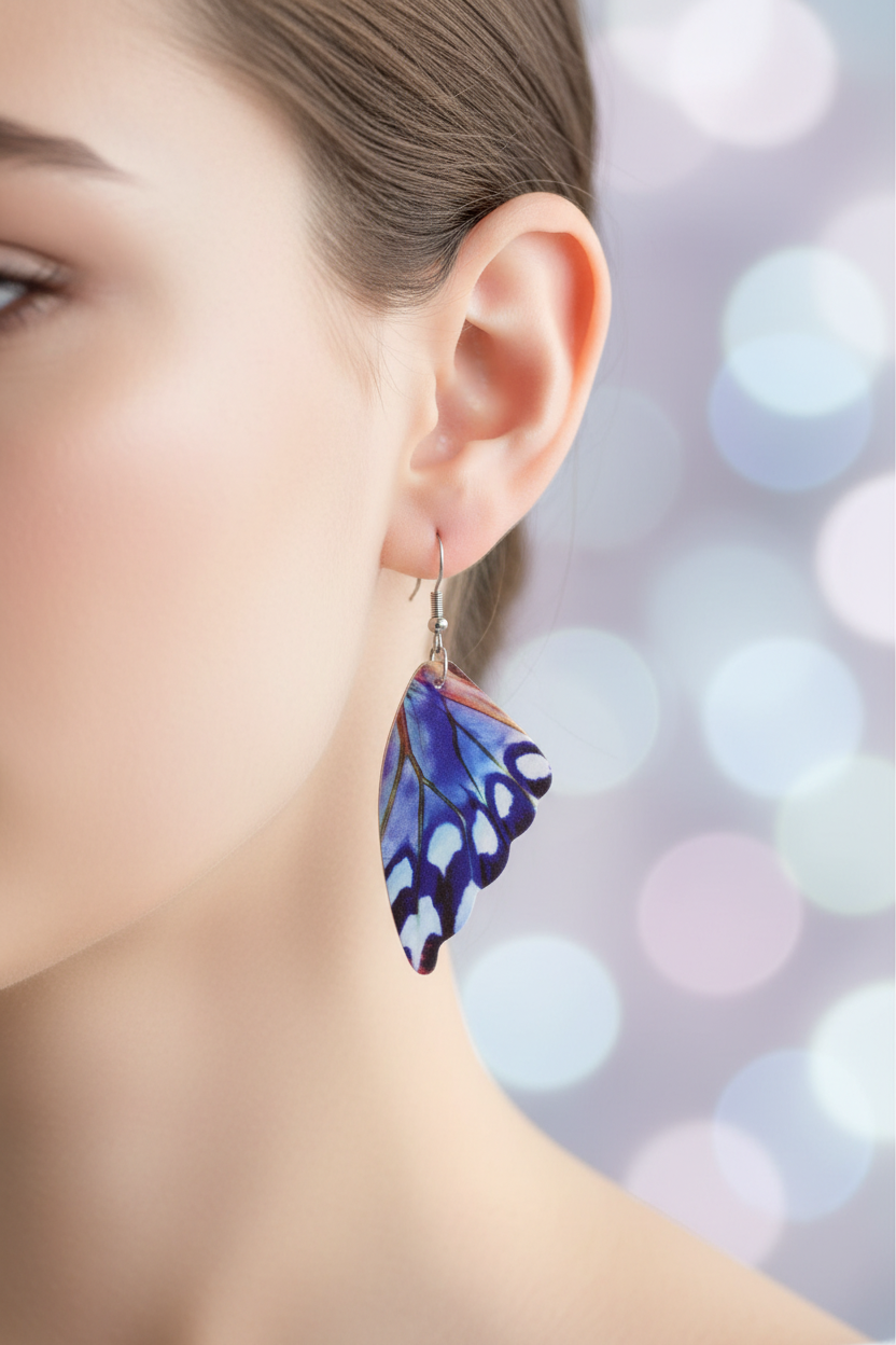 Lavender periwinkle butterfly wing earrings worn on ear with soft pastel bokeh