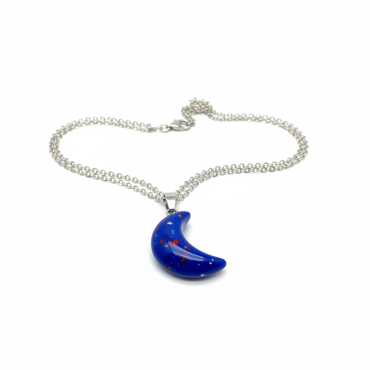 Blue crescent moon necklace with cobalt glossy stone pendant on silver chain, white background