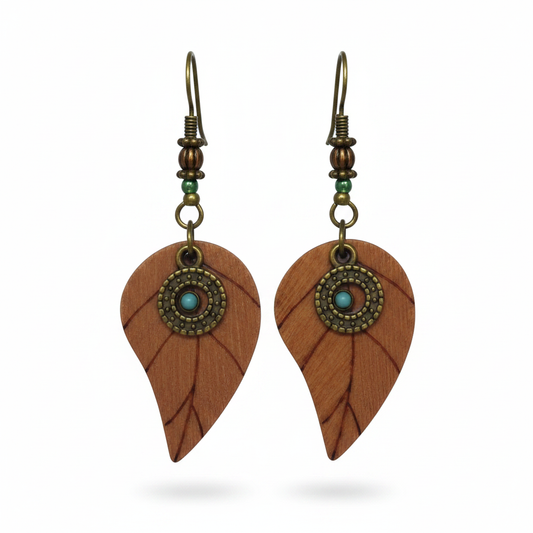 Leaf-shaped copper earrings with teal stone medallion on white background